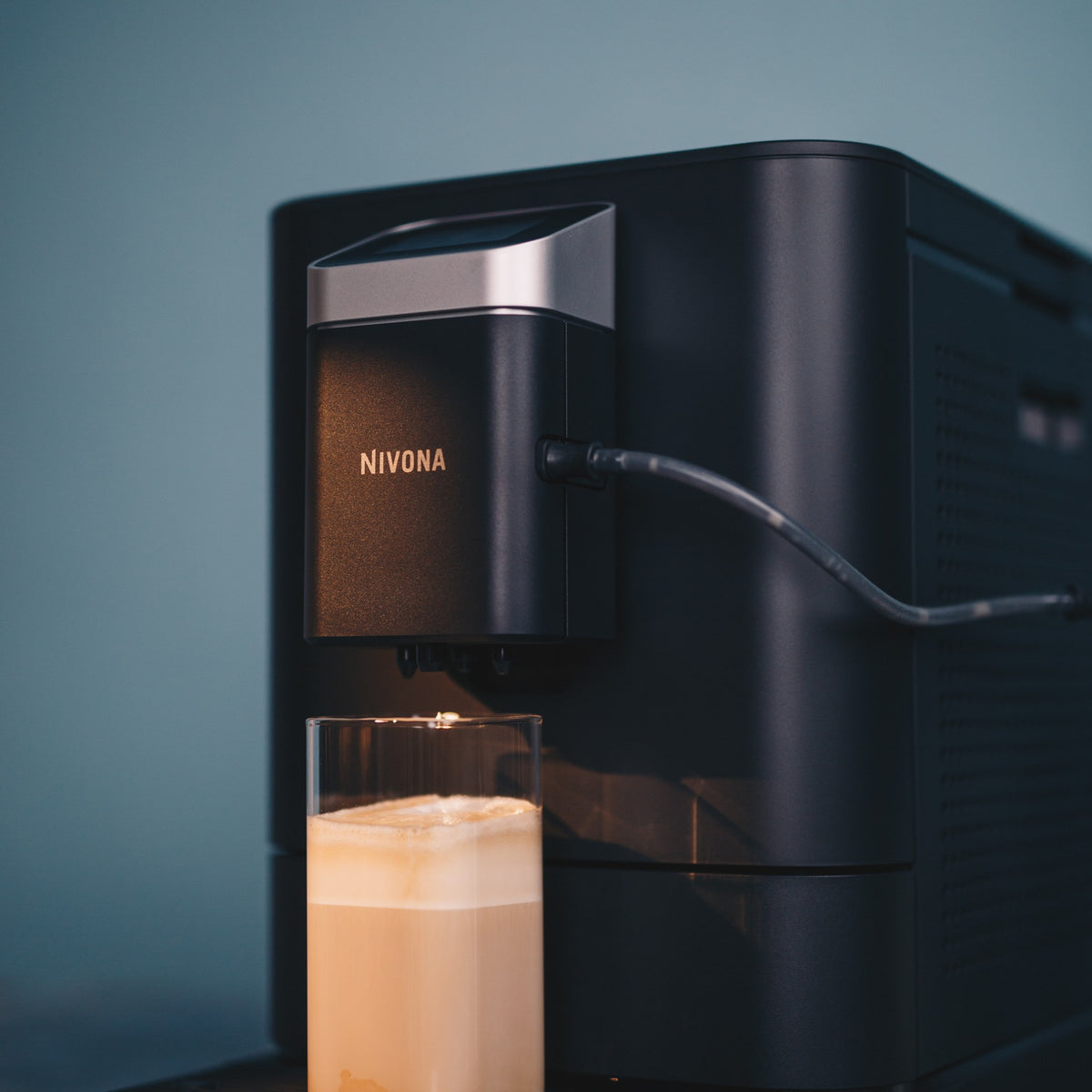 Nivona NIVO 7'101 in Schwarz in der Küche mit Milchkaffee im Glas