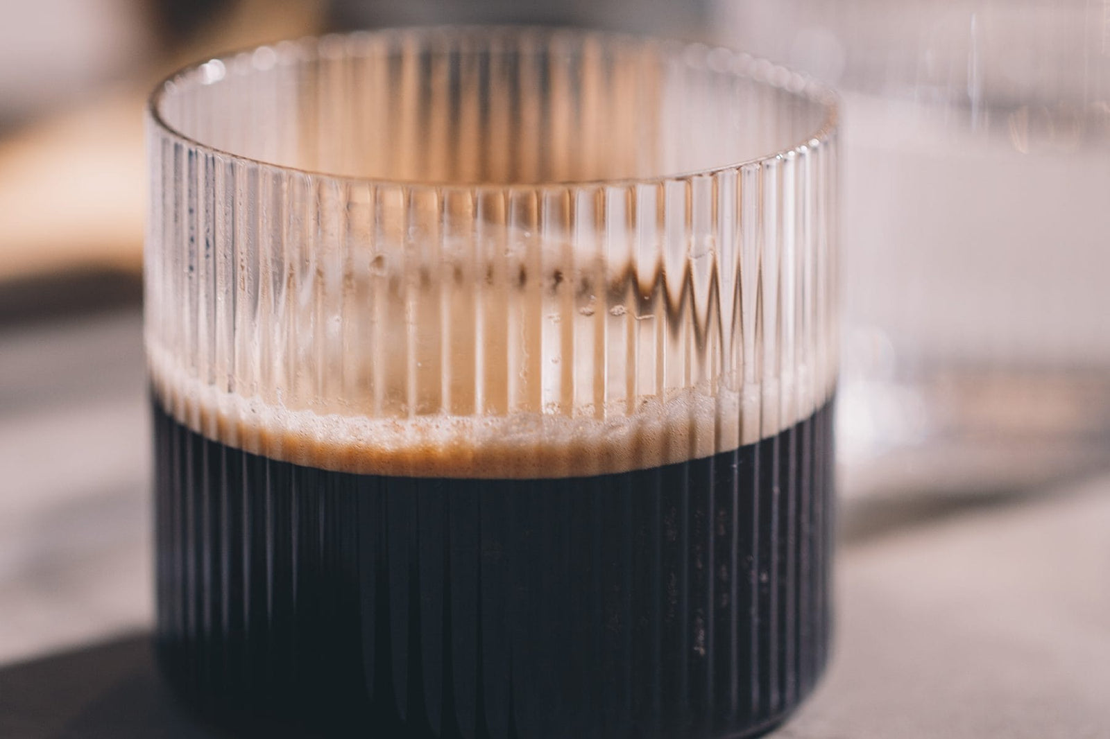Frisch gebrühter Kaffee mit Crema in einem geriffelten Glas, zubereitet mit der NIVONA NIVO 8'101