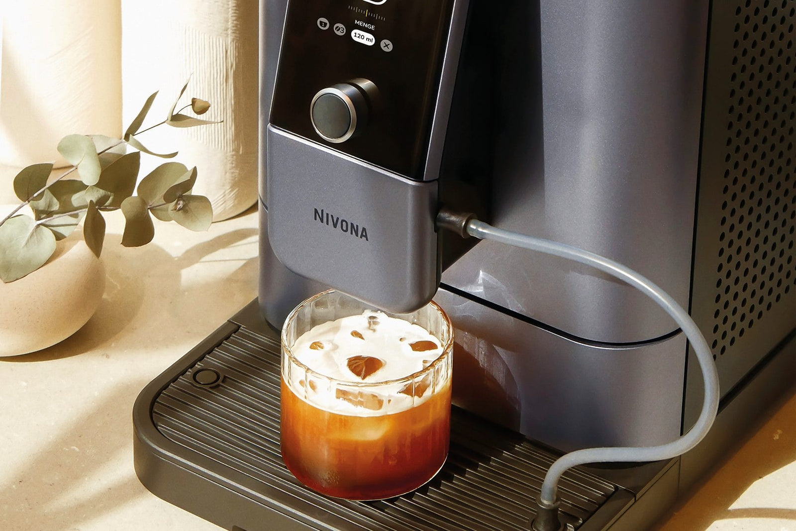 NIVONA NIVO 8'107 in Perlenblau bereitet einen Chilled Espresso zu, das Glas ist mit Eiswürfeln gefüllt