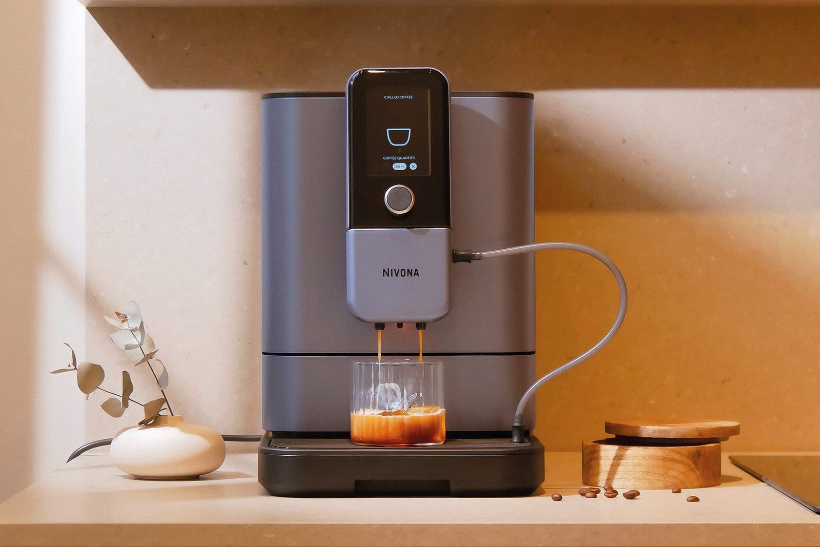 NIVONA NIVO 8'107 Kaffeevollautomat in Perlenblau auf einem Regal, ein Espresso läuft ins Glas
