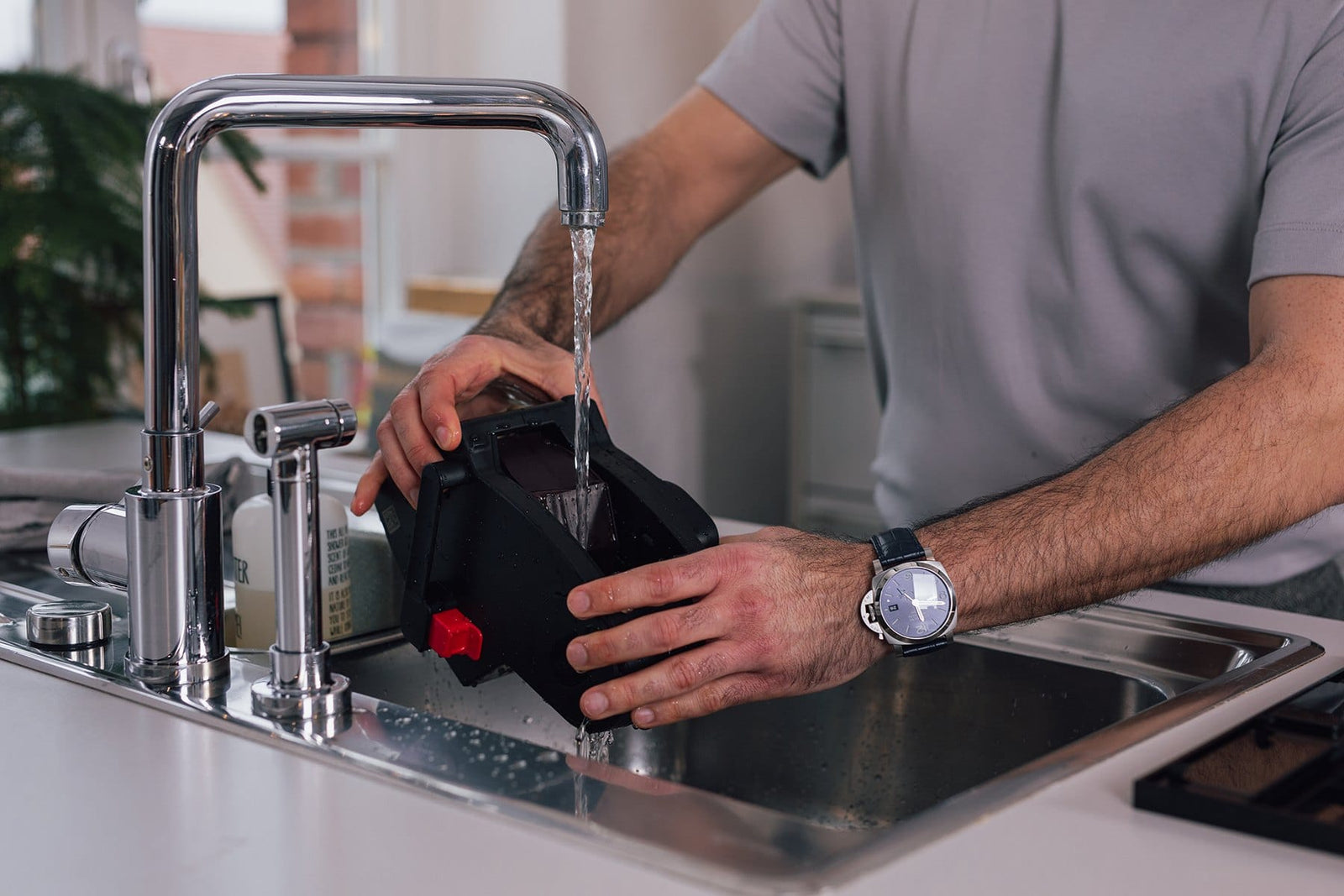 Herausnehmbare Brüheinheit eines NIVONA Kaffeevollautomaten wird unter fließendem Wasser abgespült