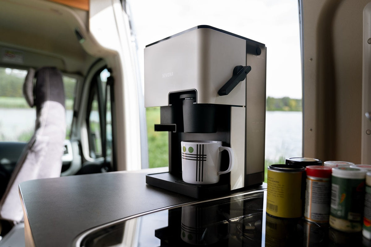 Nivona CUBE 4' in Cremeweiß im Wohnmobil mit Tasse