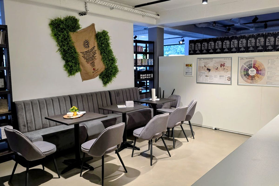 Schulungsraum der Coffee Academy von Rheinland.Coffee mit Sitzbank, Tischen und Aromarad an der Wand