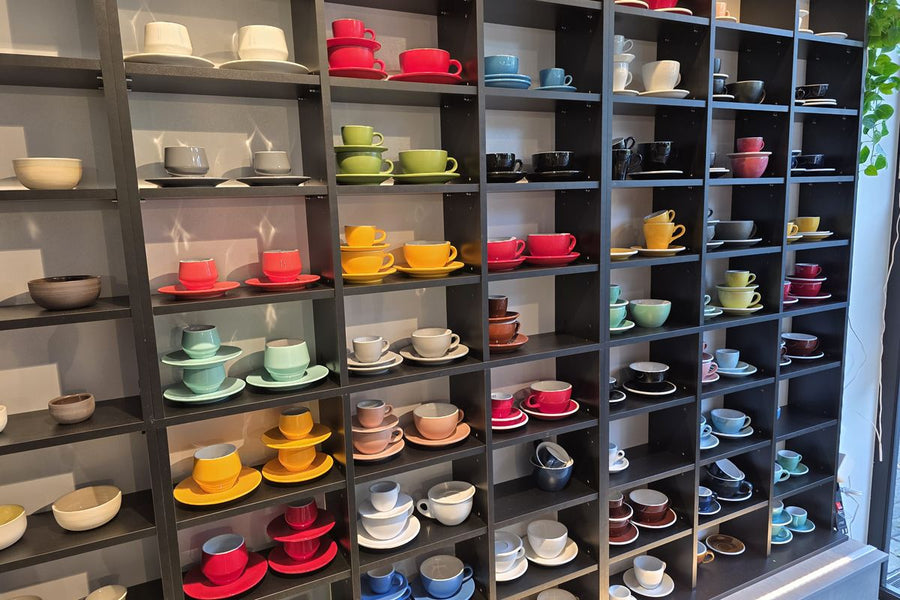 Regalwand mit Espressotassen und Porzellan in vielen Farben im Showroom von Rheinland.Coffee